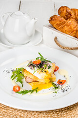 Sandwich with vegetables and an egg on a white round plate
