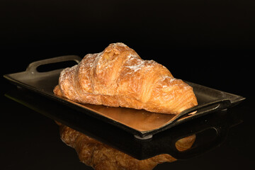 Homemade croissants, close-up, on a black background.
