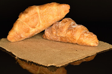 Homemade croissants, close-up, on a black background.