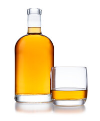 A full bell shaped bottle of golden whisky, with no label or branding, and a glass of whisky, isolated on white
