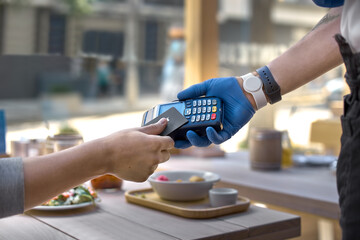 Use payment terminal with contactless credit card with NFC technology for paying in cafe or...