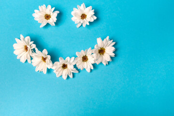 Smiley lined with daisies on a blue background