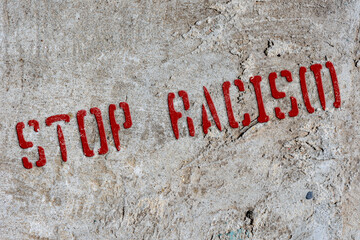 Stencil stop racism on an old concrete wall. Background. Collage. Concept.