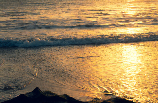 Shocking sun drop with vibrant colors. Golden water at sunset. Vacation landscape in the tropics.