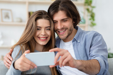 Beautiful married couple taking selfie with smartphone