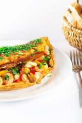 Hot breakfast. Omelette with seafood and vegetables.