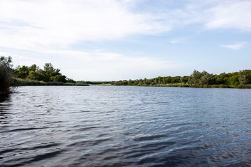 beautiful lake with small waves on the background of sky with clouds. A typical pond in the countryside