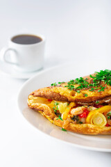 Hot breakfast. Omelette with seafood and vegetables.