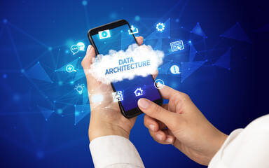 Female hand holding smartphone with DATA ARCHITECTURE inscription, cloud technology concept