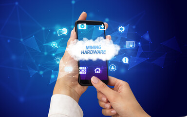 Female hand holding smartphone with MINING HARDWARE inscription, cloud technology concept