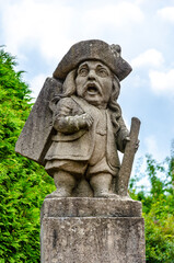 Fototapeta na wymiar Statue of a dwarf (carved by workshop of baroque sculptor Matthias Bernard Braun) in the garden of the castle, Nove Mesto nad Metuji, Czech republic.