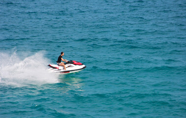 Fototapeta na wymiar Antalya, Turkey, may 25, 2020. A man drives a jet ski on the waves of the blue sea