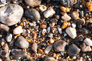 Smooth wet beach stones. North of France, Normandy. Flat lay top view. Background texture