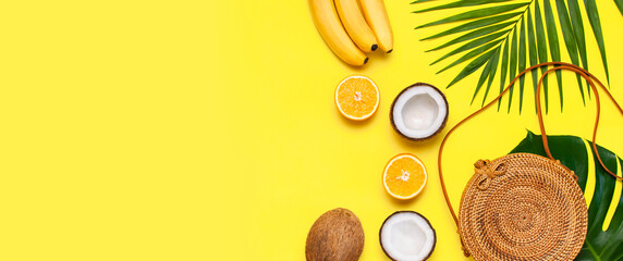 Summer fashion flat lay. Round trendy rattan bag, tropical palm leaves, coconut, orange, bananas on...