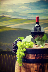 Obraz na płótnie Canvas red wine bottle and wine glass on wodden barrel