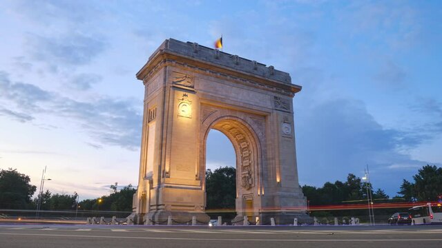 Arch of Triumph in Bucharest, Romania. Day to night looping hyperlapse in the evening, at blue hour, with car lights trails. City life, urban scene, transport, cityscape, sightseeing, travel concept.