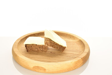 Slices of black cereal bread with butter on a white background.