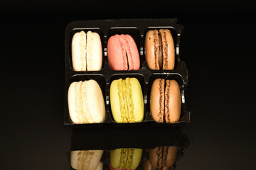 Tasty multi-colored, sweet macaroons, on a black background.