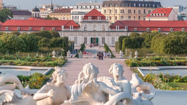 Belvedere palace with beautiful floral garden and fountain timelapse, Vienna Austria. Blue sky with clouds on sunny day. Green lawn and historic buildings
