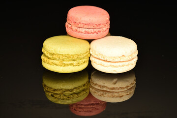 Tasty multi-colored, sweet macaroons, on a black background.