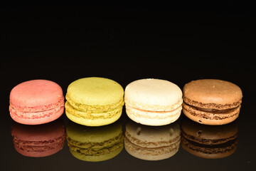 Tasty multi-colored, sweet macaroons, on a black background.