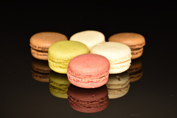 Tasty multi-colored, sweet macaroons, on a black background.