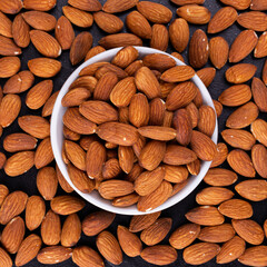 Dried almond on black stone background
