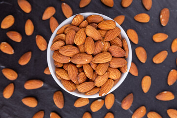 Dried almond on black stone background
