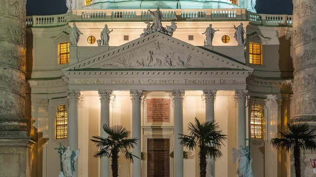 Karlskirche on the Karlsplatz square night timelapse in Vienna, Austria. People walking and sitting at fountain. It is a catholic church, also called Rektoratskirche, with a typical baroque