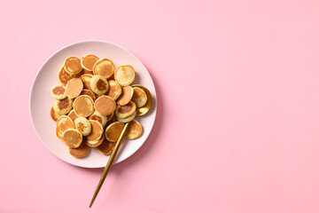 Tiny cereals pancake on pink. View from above. Trendy tasty breakfast. Copy space.