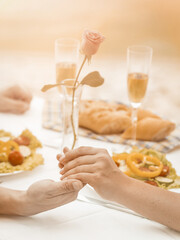 Romantic couple holding hands. Selective focus on Caucasian male and female hands holding together in foreground. Close up. Tinted image.