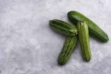 Fresh zucchini on a gray background. View from above. Free space for an inscription.