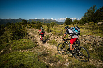 Two mountain bikers on a rocky path in the low Pyrenees. Huesca, Spain.