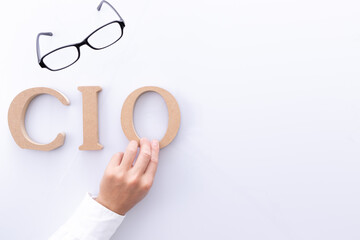 CIO（最高情報責任者）のロゴと男性の手とメガネ