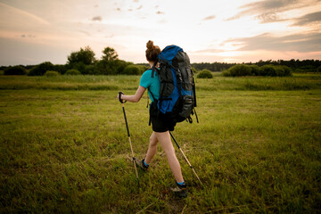 rear view of woman with sports outfit who walking along grassy field