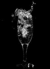 Splashes and drops of water in a glass are isolated on a black .
