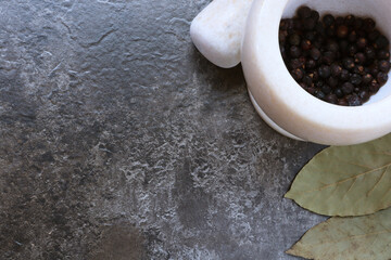 Bay leaf, pepper and marble mortar on a brown background with space for text. Bay leaf. Spices with...