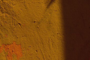 Mustard color background with shadow. Rugged mustard color wall with shadow.