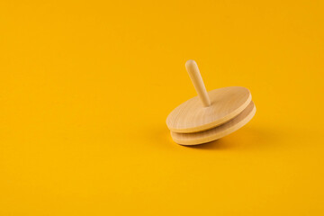 Children's wooden toy spinning top close up with copy space. Concept of educational games