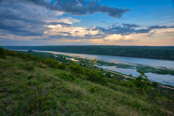river in green landscape and dramatic clouds with blue sky