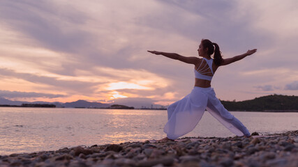Young woman is practicing yoga at mountain lake
