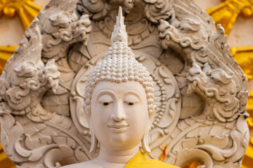 White stucco Buddha head statue And the morning sun