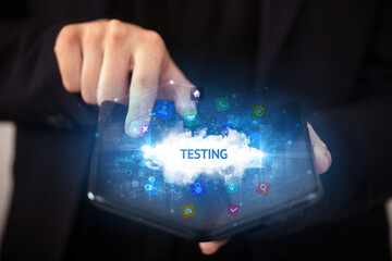 Naklejka premium Businessman holding a foldable smartphone with TESTING inscription, technology concept