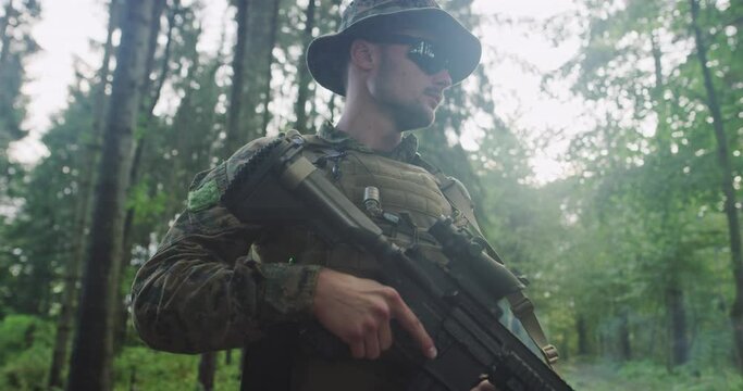 Portrait of soldier with riffle in dense forest