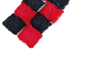 One set of California rolls covered red tobiko and black tobiko on a white background.