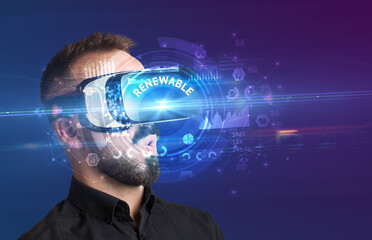 Businessman looking through Virtual Reality glasses with RENEWABLE inscription, innovative technology concept