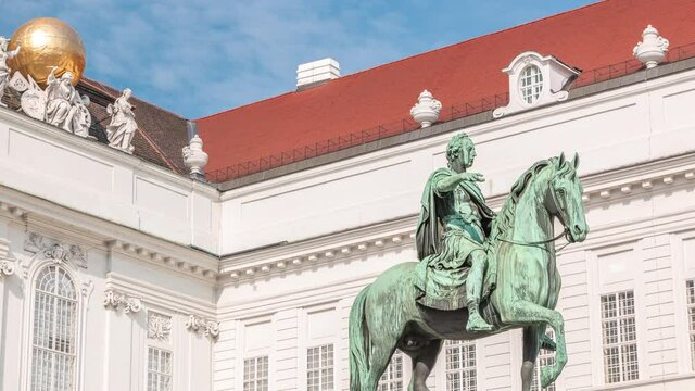 Equestrian statue of Holy Roman Emperor Joseph II riding a horse in Josefsplatz Square timelapse, Hofburg Palace in Vienna, Austria. Austrian National Library on a background