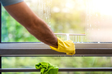 Professional window cleaner an blue t-short and gloves soaps and squeegees a window clean