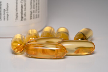 fish oil capsules in front of jar on white background