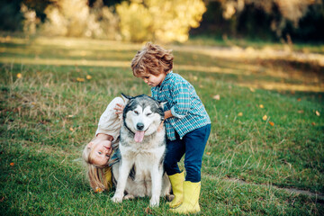 Naklejka na ściany i meble Active children concept. Boy and girl brother and sister traveling away from home. Children lovingly embraces his pet dog.